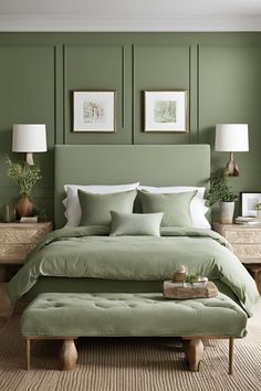 a bed with green sheets and pillows in front of two framed pictures on the wall