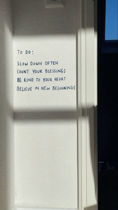 a white door with writing on it and a window in the background that says to do slow down often count your blessing be kind of your heart believe in new beginnings