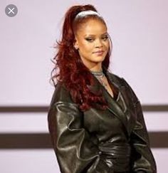 a woman with red hair wearing a black leather jacket