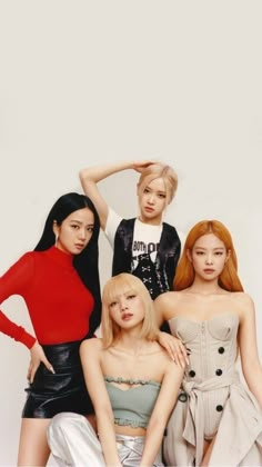 four young women posing for a photo in front of a white wall with red hair