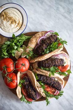 an overhead view of some tacos with tomatoes, onions and lettuce on the side