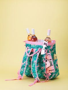 a pink and green bag with bottles in it