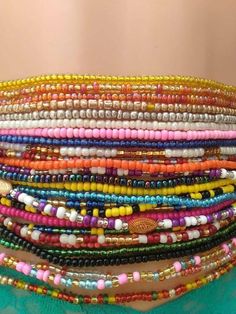 a stack of multicolored bracelets sitting on top of a woman's stomach