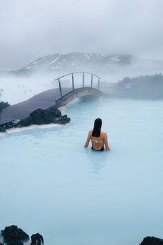 a woman sitting in the middle of a blue lagoon