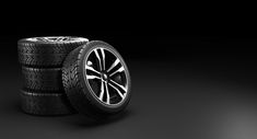 three tires stacked on top of each other in front of a black background with light