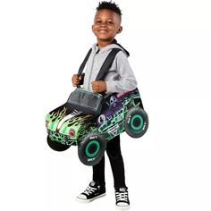 a young boy is holding a monster truck bag