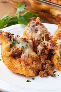 three stuffed shells with meat and cheese on a white plate