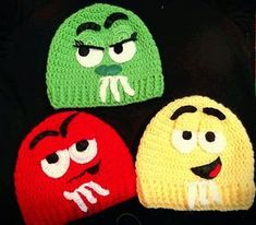 three crocheted hats with faces on them