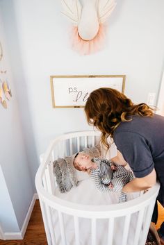 a woman is playing with her baby in the crib