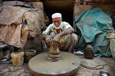 an old man is making something out of clay