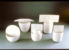 five pieces of white pottery sitting next to each other