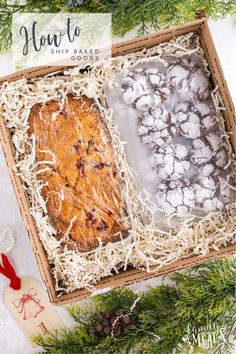 an open box filled with cookies and icing next to pine branches on top of snow covered ground