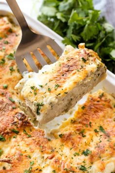 a close up of a fork in a casserole dish with meat and cheese