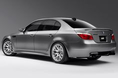 the rear end of a silver car on a gray background