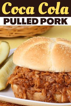 a pulled pork sandwich on a plate with pickles and banana slices in the background