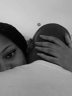 a black and white photo of a woman laying in bed with her head on the pillow