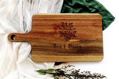 a wooden cutting board with the words year and place on it next to some flowers