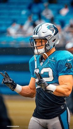 a close up of a football player wearing a helmet and holding a ball in his hand