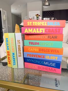 a stack of books sitting on top of a glass table