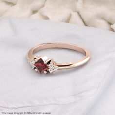 a close up of a ring with a red stone in it on a white blanket