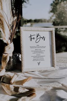 a sign that is sitting on top of a table next to a vase with some flowers