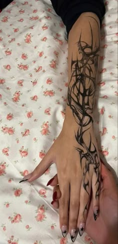 a woman's arm and hand with tattoos on it