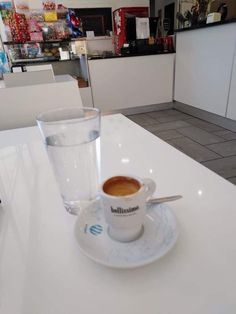 a cup of coffee sitting on top of a white table