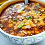 a bowl of chili soup with corn on the side