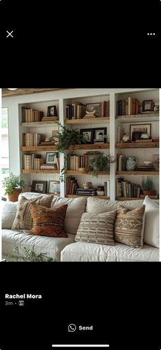 a living room filled with lots of furniture and bookshelves on the wall above