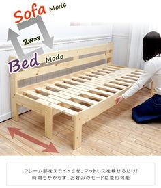 a woman kneeling on the floor next to a bed frame