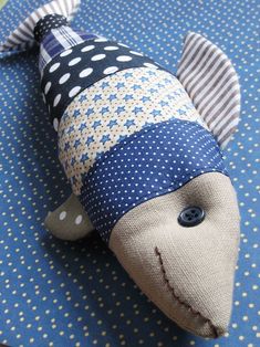 a stuffed animal that is laying down on a tablecloth with polka dots and stripes