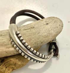 This is called a half cuff bracelet; it is half doubled soft brown leather cord and half silver alloy metal with a hook closure. The metal is bright silver zamak which is hypoallergenic, lead free and tarnish resistant.  To me it resembles the tentacles of an octopus arm, but others have said it looks more like the frond of a fern - I will leave that up to you to decide but either way it is quite pretty!  It looks great on its own or stacked with other bracelet pieces such as beadwork or chains.  We have only one of these special pieces and it is sized to fit a 15 to 17 cm wrist (6 to 7 inch) - this is about a small to average women's size.  Check out our shop to see our other unusual jewelry pieces.  We offer free shipping over 35 dollars and we ship quickly too! Handmade Brown Leather Friendship Bracelet, Brown Leather Bracelet With Sliding Knot For Everyday, Adjustable Double Band Brown Wrap Bracelet, Adjustable Brown Double Band Bracelets, Adjustable Nickel-free Brown Wrap Bracelet, Adjustable Brown Wrap Bracelet Nickel Free, Adjustable Brown Nickel-free Wrap Bracelet, Nickel-free Brown Leather Bracelet As Gift, Nickel-free Brown Leather Bracelet Gift