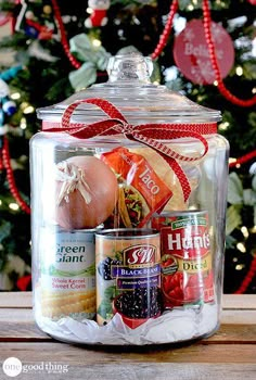 a glass jar filled with food next to a christmas tree