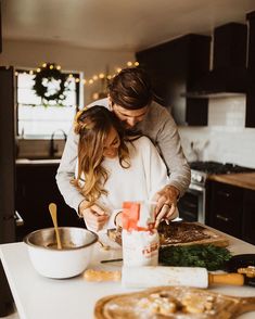 a man and woman are preparing food in the kitchen