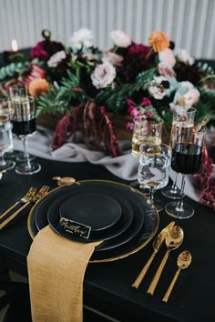 black and gold place setting with flowers in the background