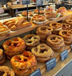 many different types of doughnuts on display in a store