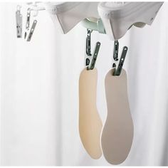 two kitchen utensils hanging from hooks on a curtain