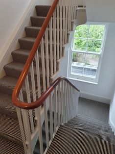 the stairs are made of wood and have striped carpet