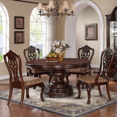 a dining room table with chairs and a china cabinet in the corner on top of a rug