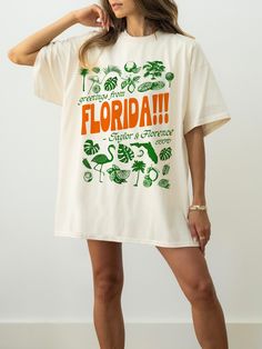 Florida Fan Merch T-Shirt celebrating the Taylor + Florence And The Machine track on The Tortured Poets Department TTPD. Swiftie merch features text, "Greetings from Florida - Taylor & Florence", with Florida text in orange and the rest in green. Text is surrounded by illustrations including flamingos, citrus fruit, and tropical plants. Shirt has a vintage postcard aesthetic and would make a great gift for any Swiftie excited for The Tortured Poets album! PRINTED ON COMFORT COLORS * 100% ring-sp Tourist T Shirt, Usa Graphic Tee, Cool Merch Design, Cute Graphic Tees Aesthetic, Florida Taylor Swift, Vintage Postcard Aesthetic, T Shirt Branding, Travel Merch, Postcard Aesthetic