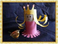 a paper doll with a crown on it and a small bird sitting next to it