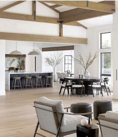 a living room filled with furniture next to a kitchen and dining room table in front of a large window