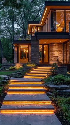 the steps are lit up with bright lights in front of this modern home at night