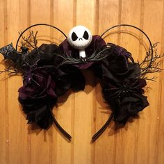 a mickey mouse ears headband with a skull and flowers on it's side