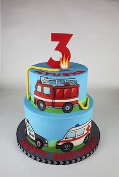 a three tiered birthday cake with firetruck and ambulances on it