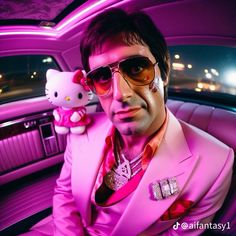 a man in a car with hello kitty on his lap and pink lighting behind him