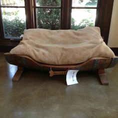 an old suitcase with a blanket on it sitting in front of a window and some windows