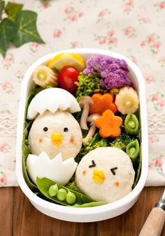 a white bowl filled with food sitting on top of a wooden table next to utensils