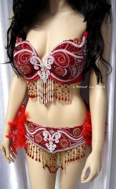 a mannequin wearing a red and gold belly dance costume with feathers on it