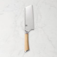 a kitchen knife with a wooden handle on a marble surface